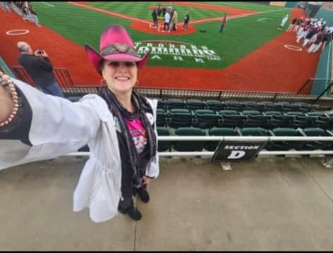 Fan in a pink cowboy hat enjoying a baseball game at Standard Park / Oil City Stadium