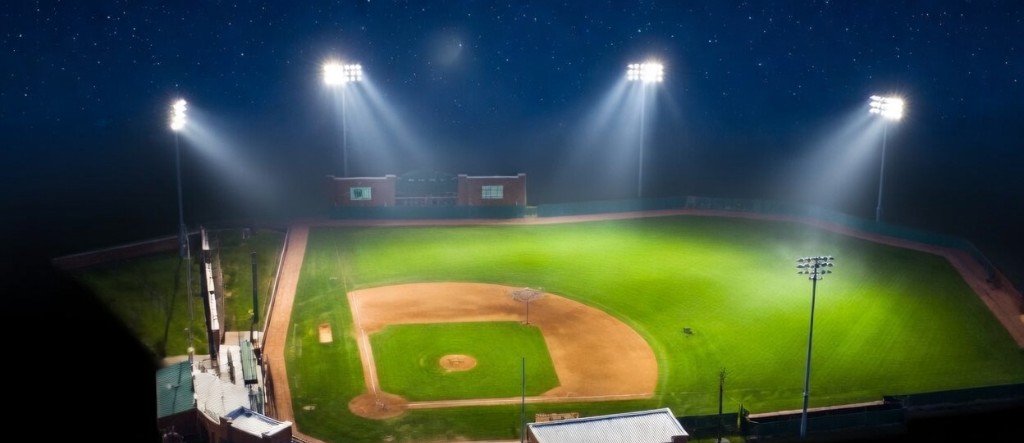 Baseball field at night lit by stadium lights - aerial view of diamond and outfield